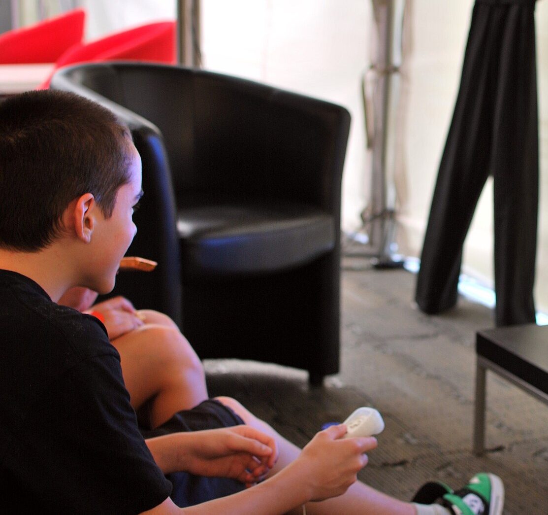 Un jeune garçon joue à un jeu vidéo sur une console de salon